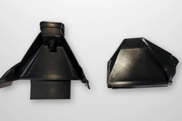 The two printed hood parts, the hood with its camera tower and the front cover, side by side